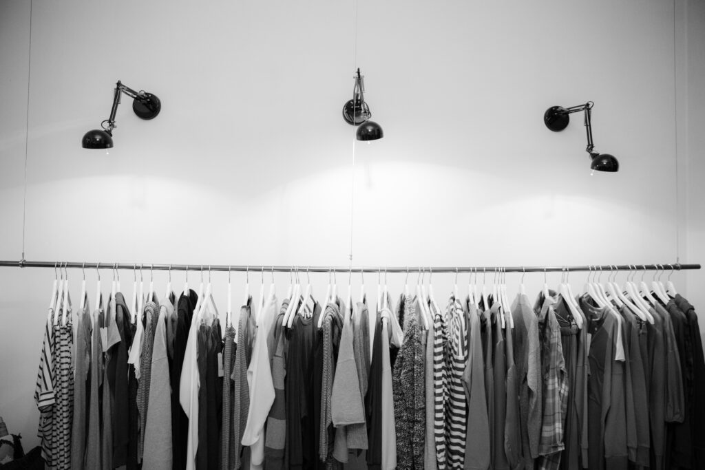 Black & white image of clothes hanging below 3 spotlights